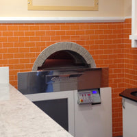 A milano fired oven enclosed by a orange brick wall design.