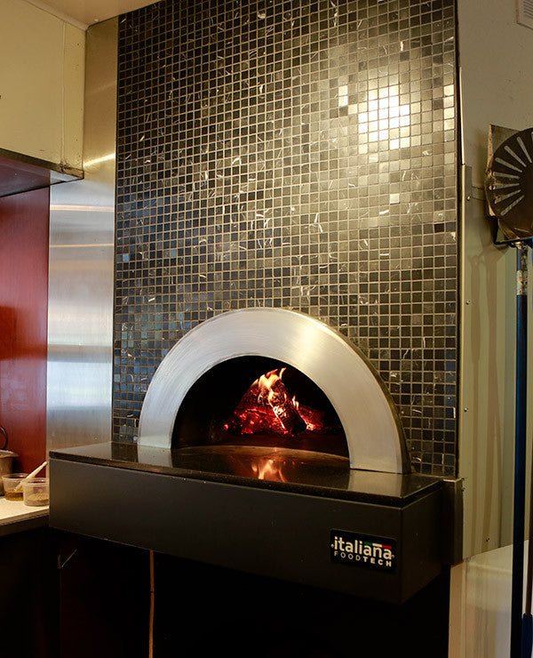 Milano fired oven enclosed within a decorated wall with custom tiling.