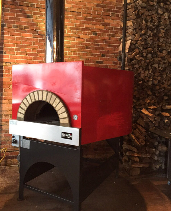 Milano fired oven with a red finish, installed and ready for use.