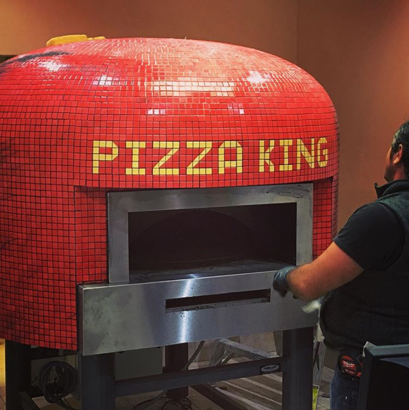 A bright red Napoli fired oven with a custom branded tiling for Pizza King.