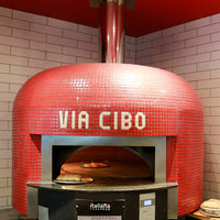 A bright red Napoli fired oven with a custom branded tiling for Via Cibo.