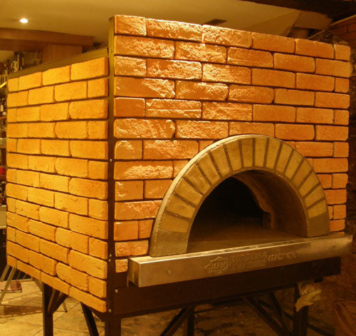 an enclosed Milano fired oven with a custom gold brick tiling design.