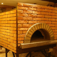 an enclosed Milano fired oven with a custom gold brick tiling design.